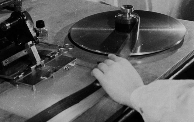 Monteerija töövahendid: montaažlaud, filmi lõikaja ja press liimimiseks. Kaader kinokroonikast „Päev Tallinna Kinostuudios“ (1950), Ringvaade „Nõukogude Eesti“ nr 4, 10. veebruar 1950, 3/4
